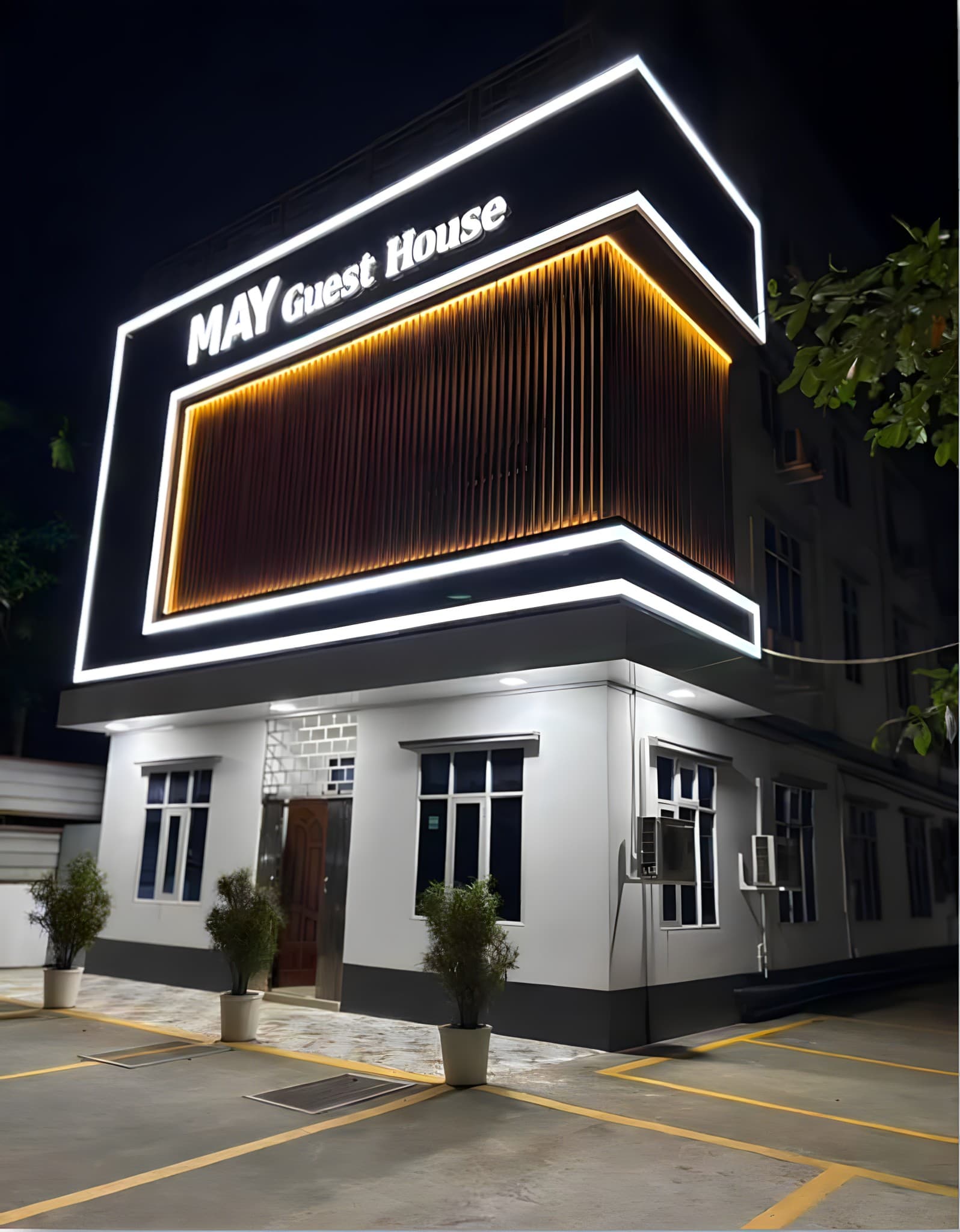 MAY Guest House illuminated at night